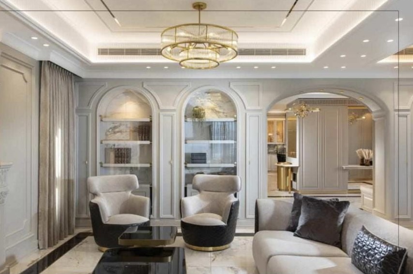 A living room with a chandelier and white furniture.