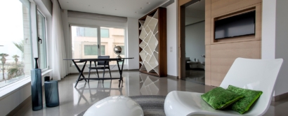 A modern living room with a white chair and a white rug.