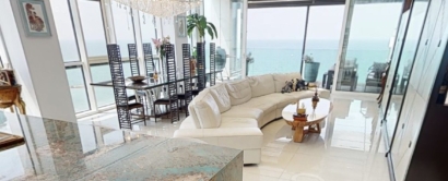 A large living room with a view of the ocean.