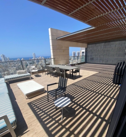 A balcony with a table and chairs with a view of the city.