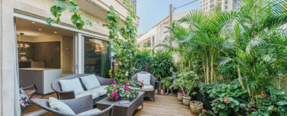 A balcony with wicker furniture and plants.