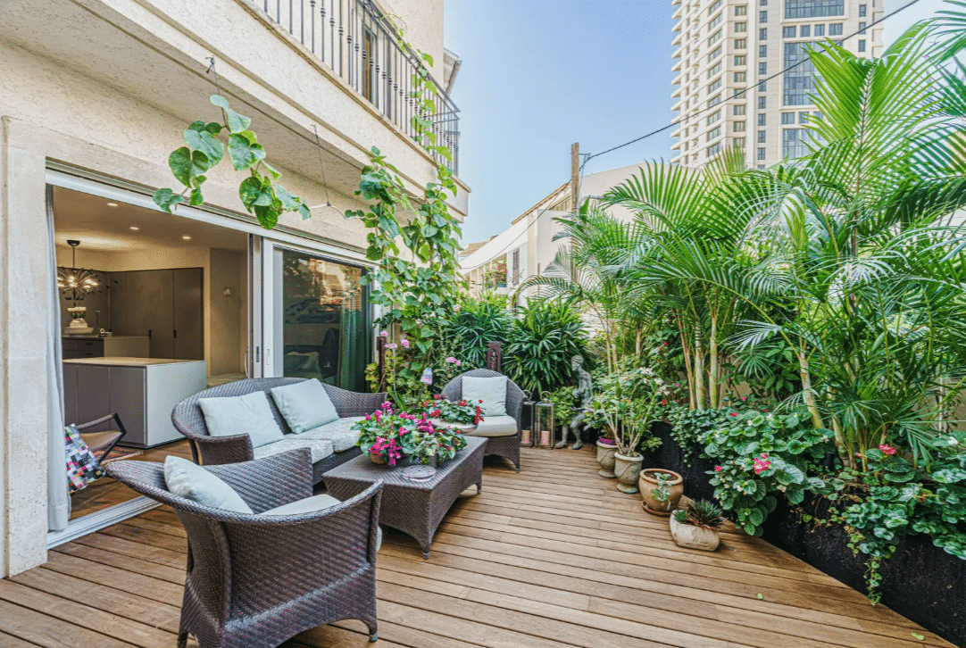 A balcony with wicker furniture and plants.