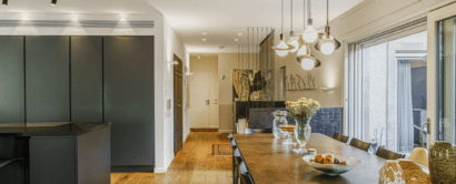 A modern kitchen with black cabinets and wooden floors.