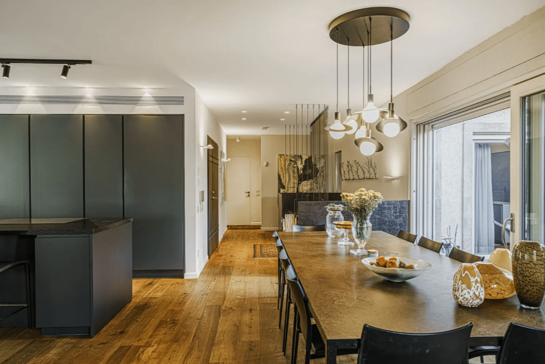 A modern kitchen with black cabinets and wooden floors.