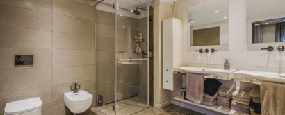 A bathroom with a glass shower stall and sink.