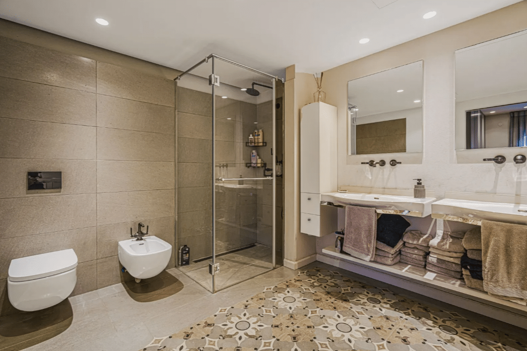 A bathroom with a glass shower stall and sink.