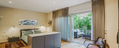 A bedroom with wooden floors and a sliding glass door.