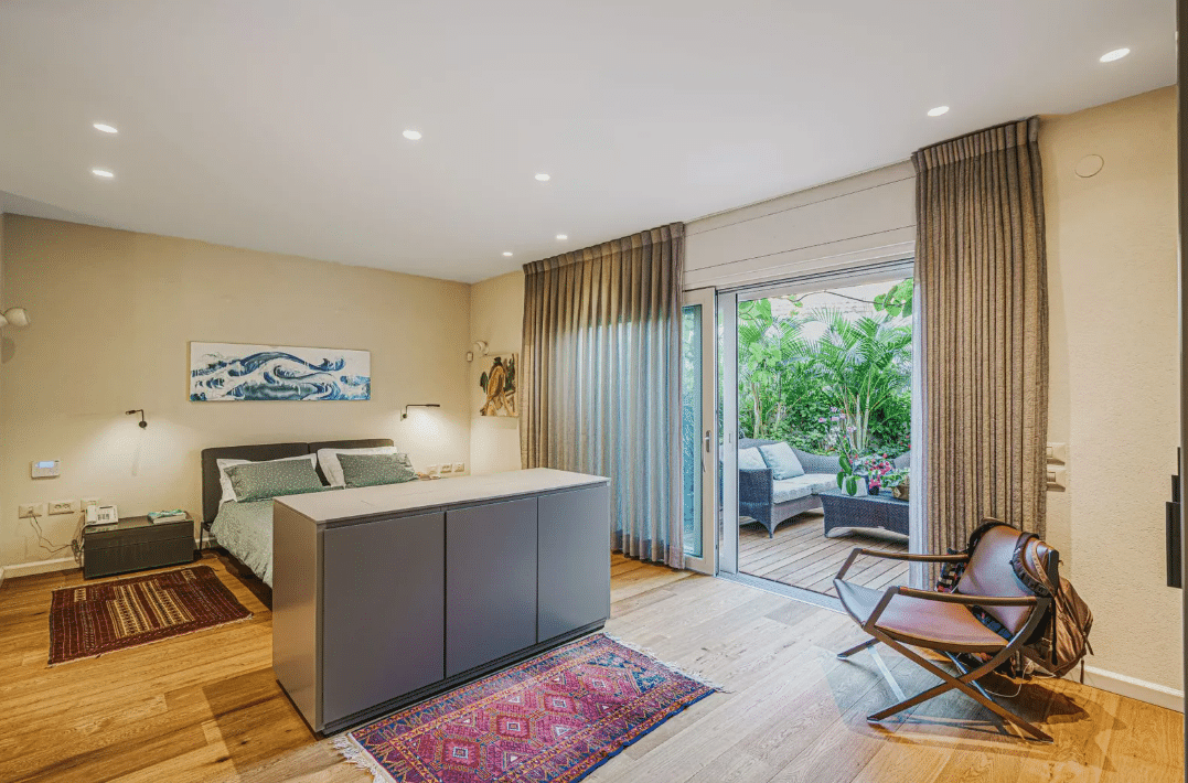 A bedroom with wooden floors and a sliding glass door.