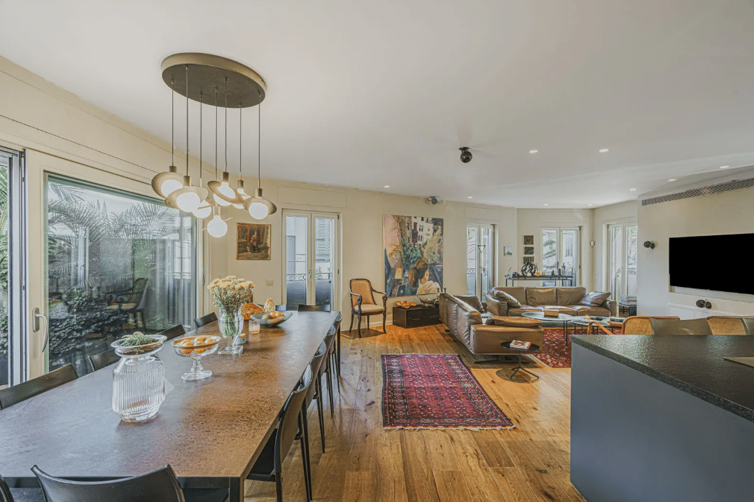 A living room with a dining table and a tv.