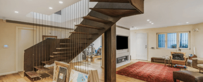 A modern living room with wooden floors and a spiral staircase.