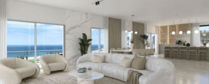 A white living room with a view of the ocean.