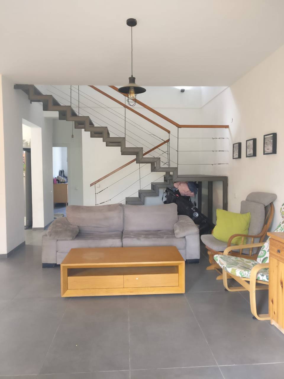 A living room with gray couches and a staircase.